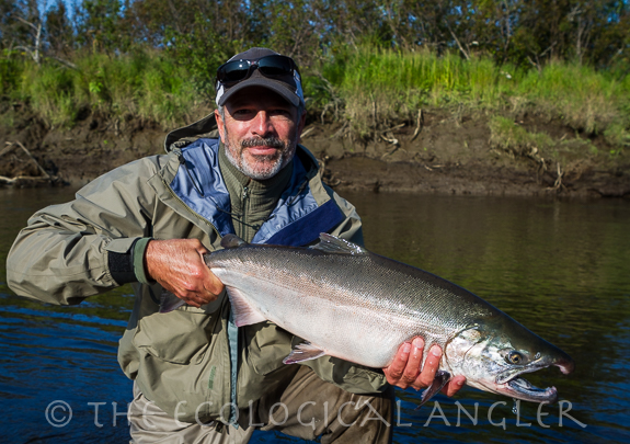Michael Carl photographed with a coho salmon caught from a river in Alaska.